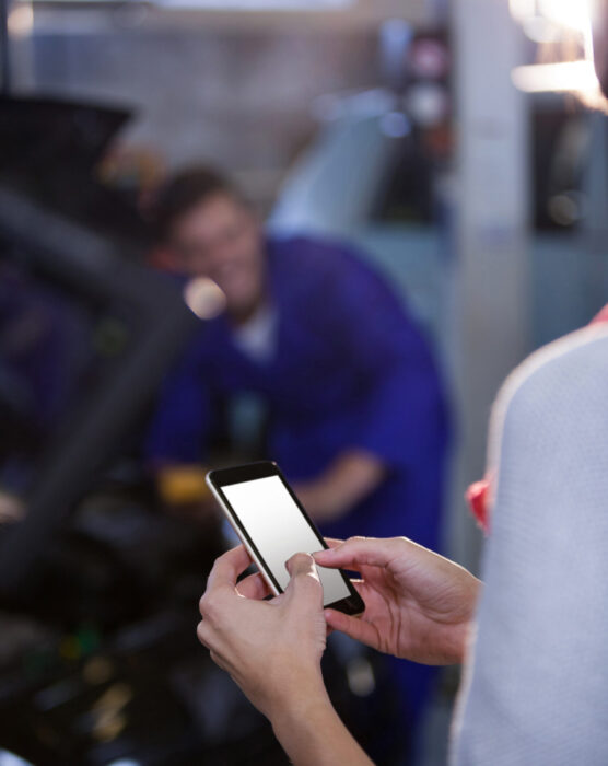 Customer text messaging on the mobile at the repair garage